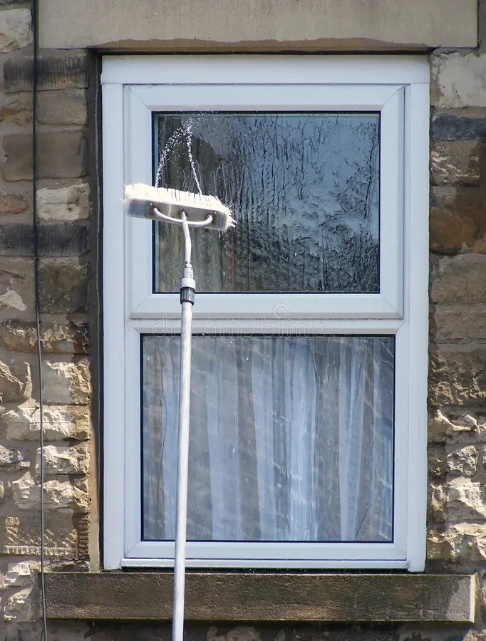 Window being cleaned with a squeegee on an extension pole